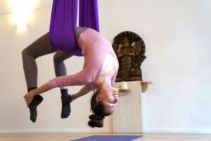 Frau im Tuch beim Aerial Yoga