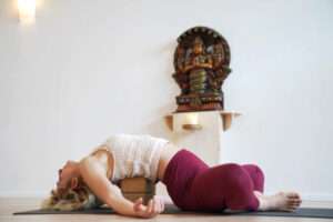 Frau in Rückbeuge mit Yogablock